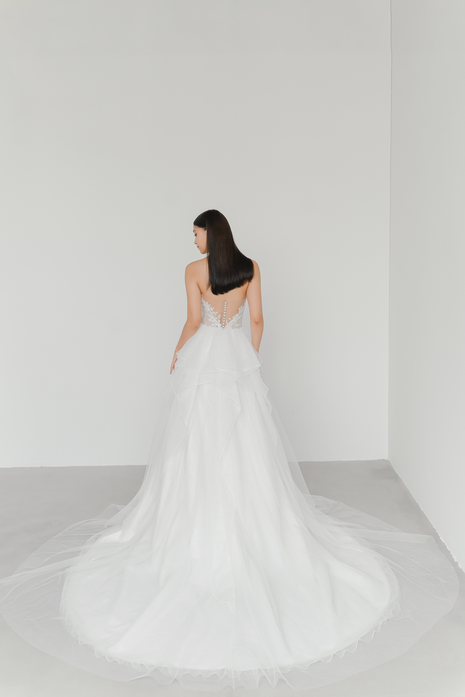 Brielle bridal gown train showcasing cascading ruffles and shimmering glitter tulle