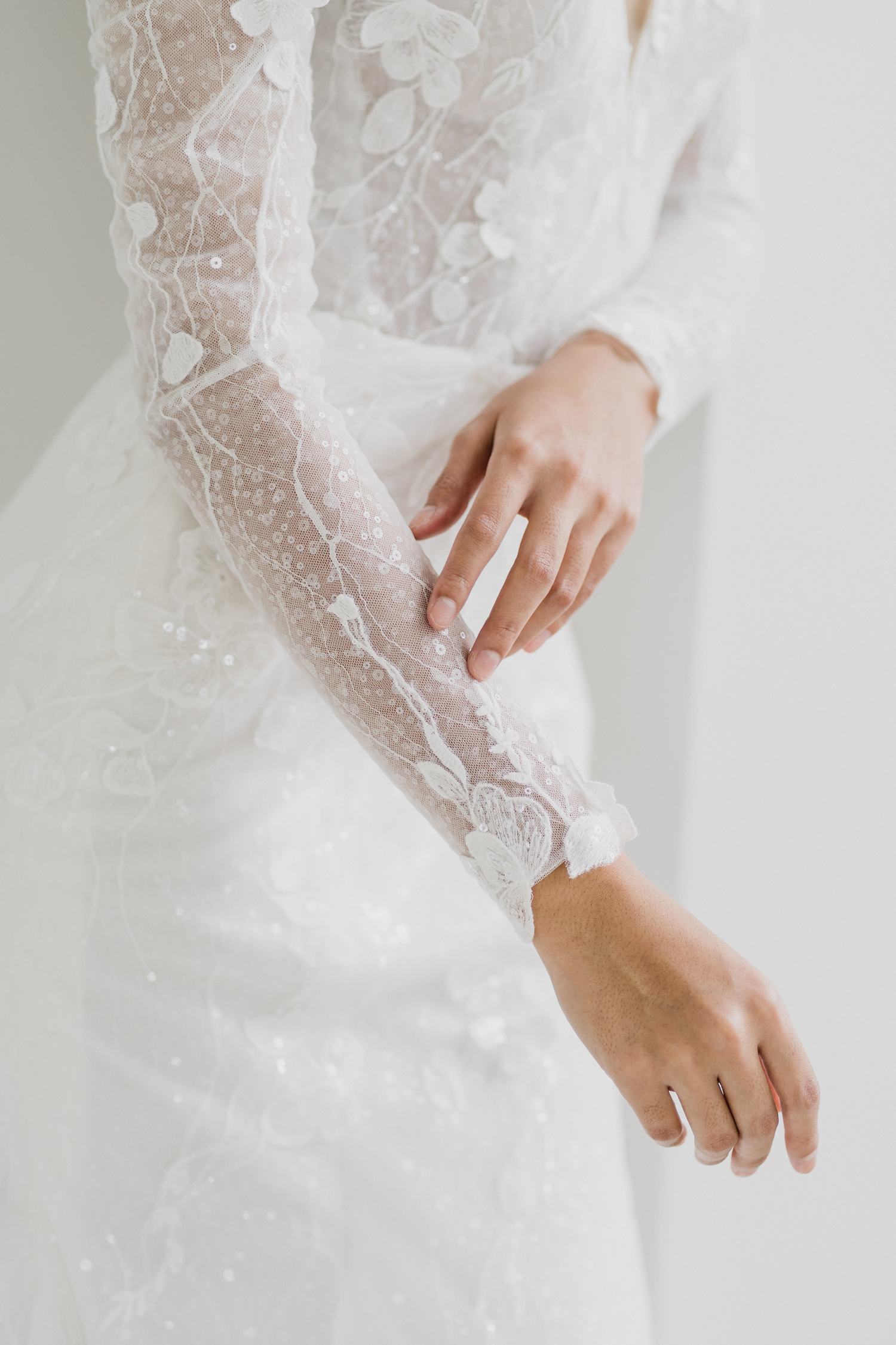 Close-up of Katrina wedding dress with floral lace appliqué and sequinned detailing