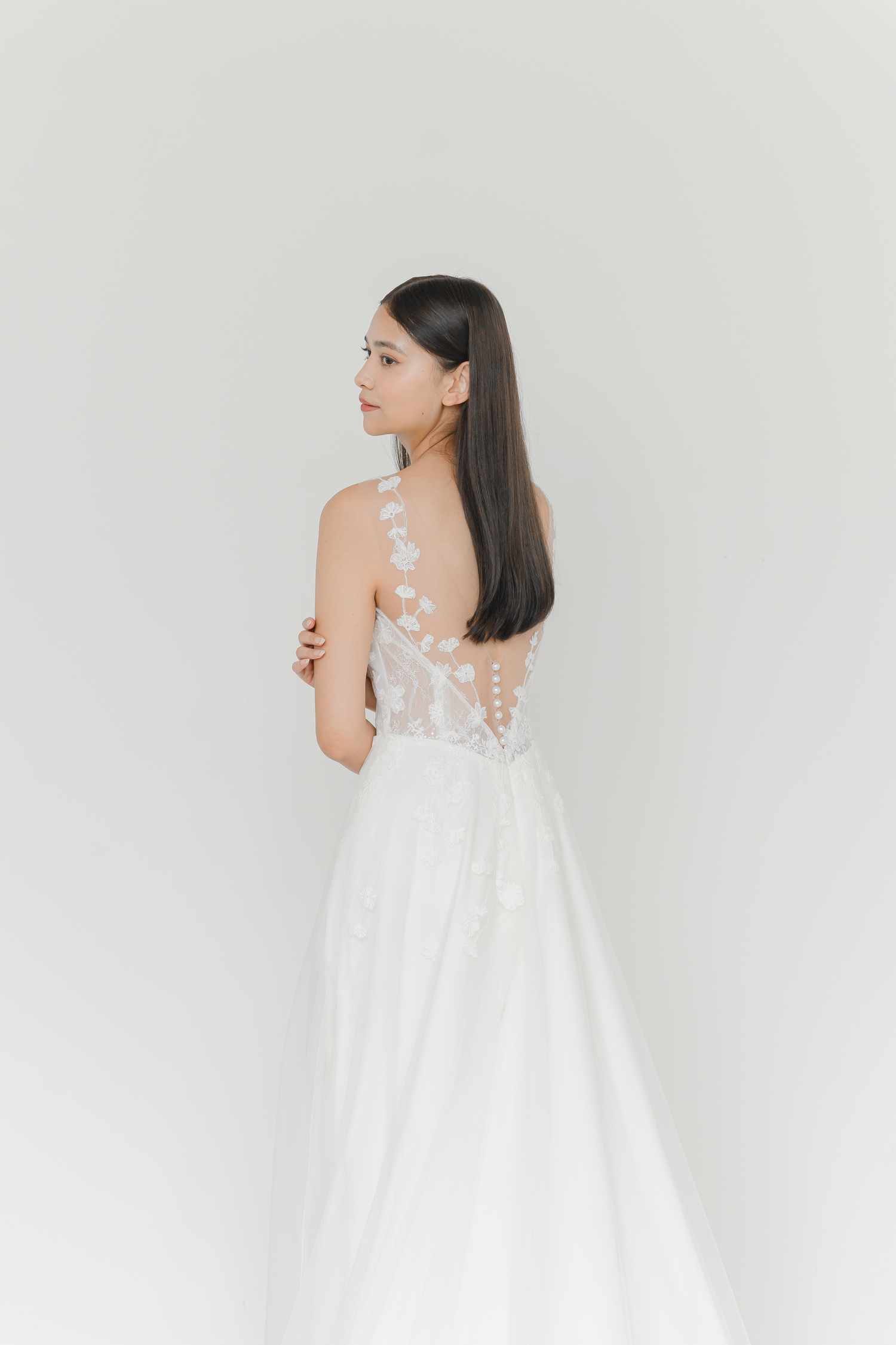 Mikaela bridal gown back view with a lace-trimmed back and pearl buttons