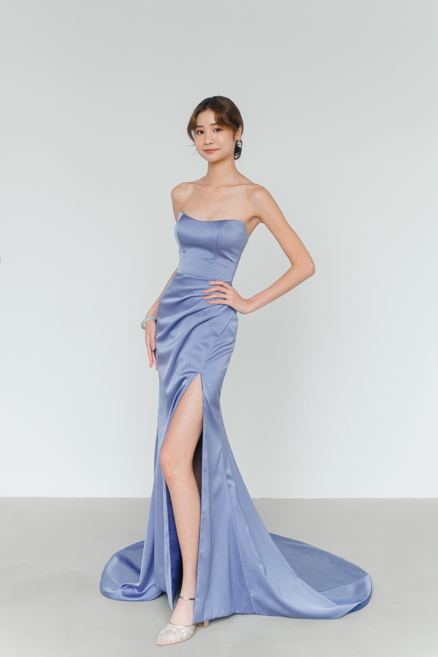 Sadie evening dress featuring softly draped waist detailing and a thigh-high slit