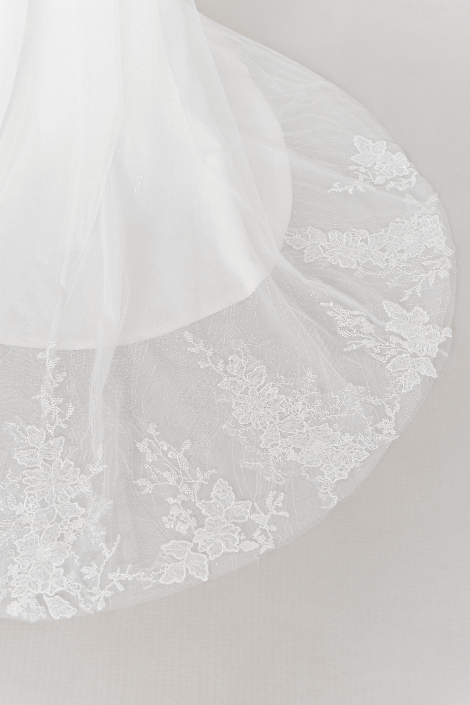 Close-up of Vivian wedding gown highlighting the intricate lace appliqués and lace-edged train