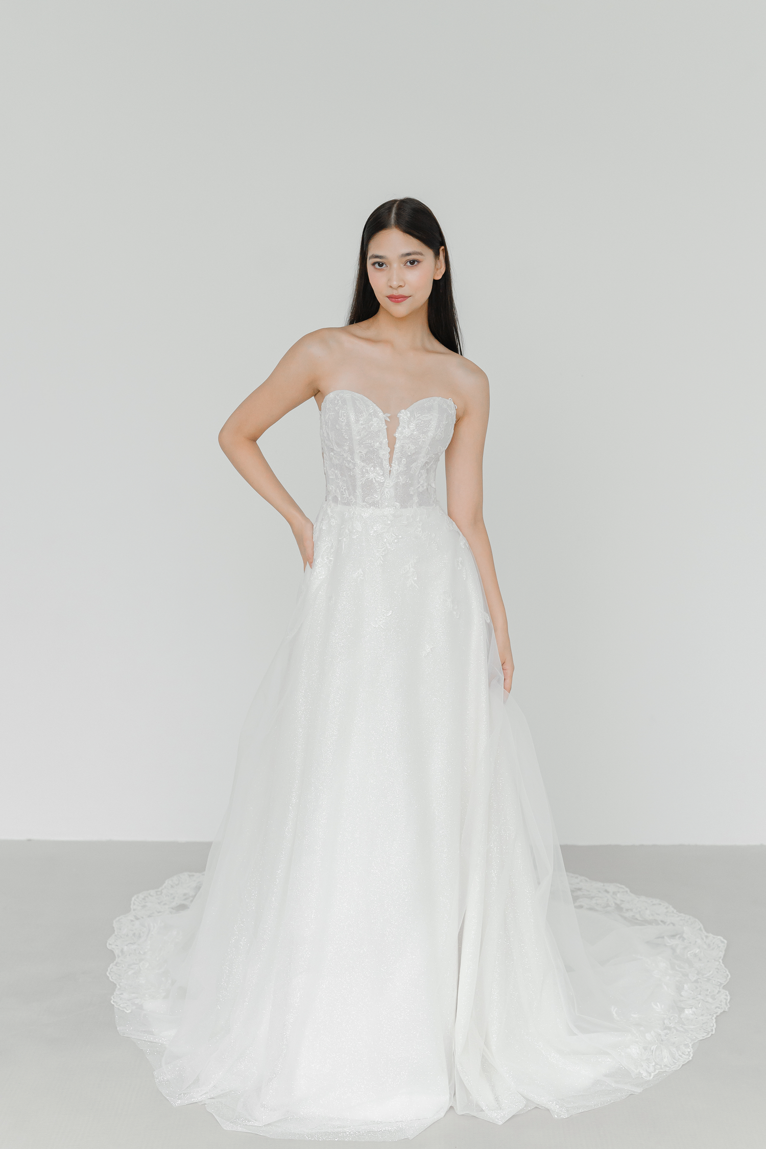 Cyra wedding dress front view with intricate lace appliqués and a glitter A-line silhouette