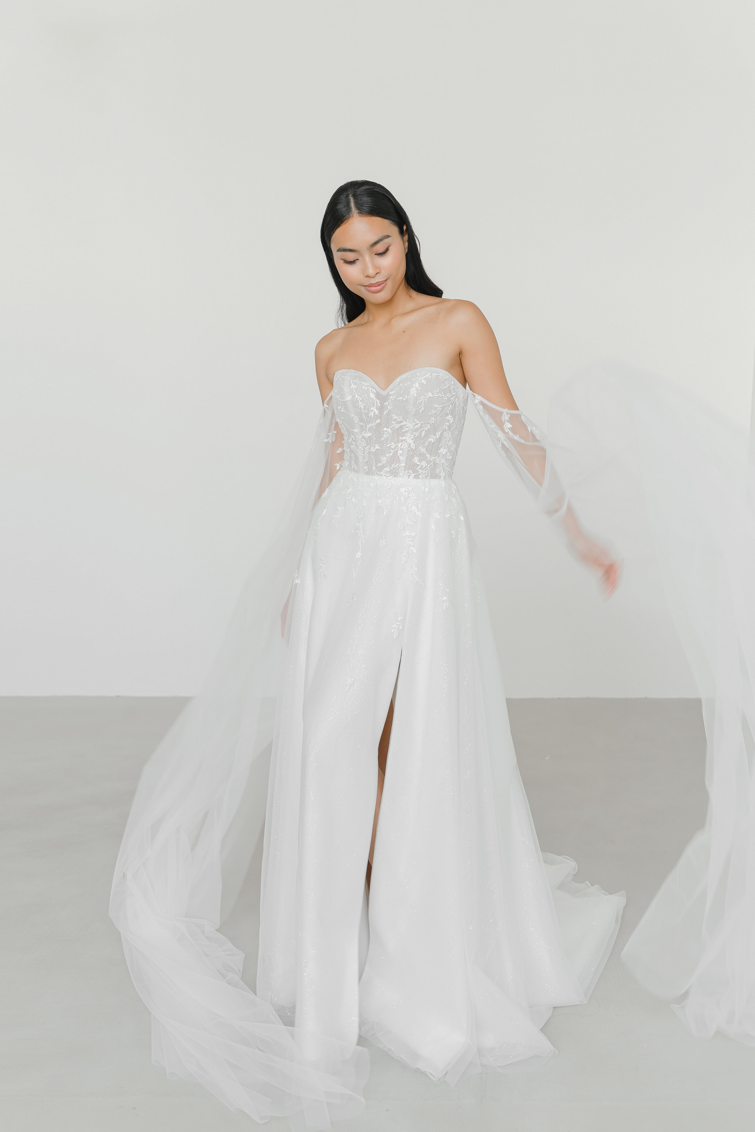 Ellery wedding gown side view with a soft front slit and flowing A-line skirt