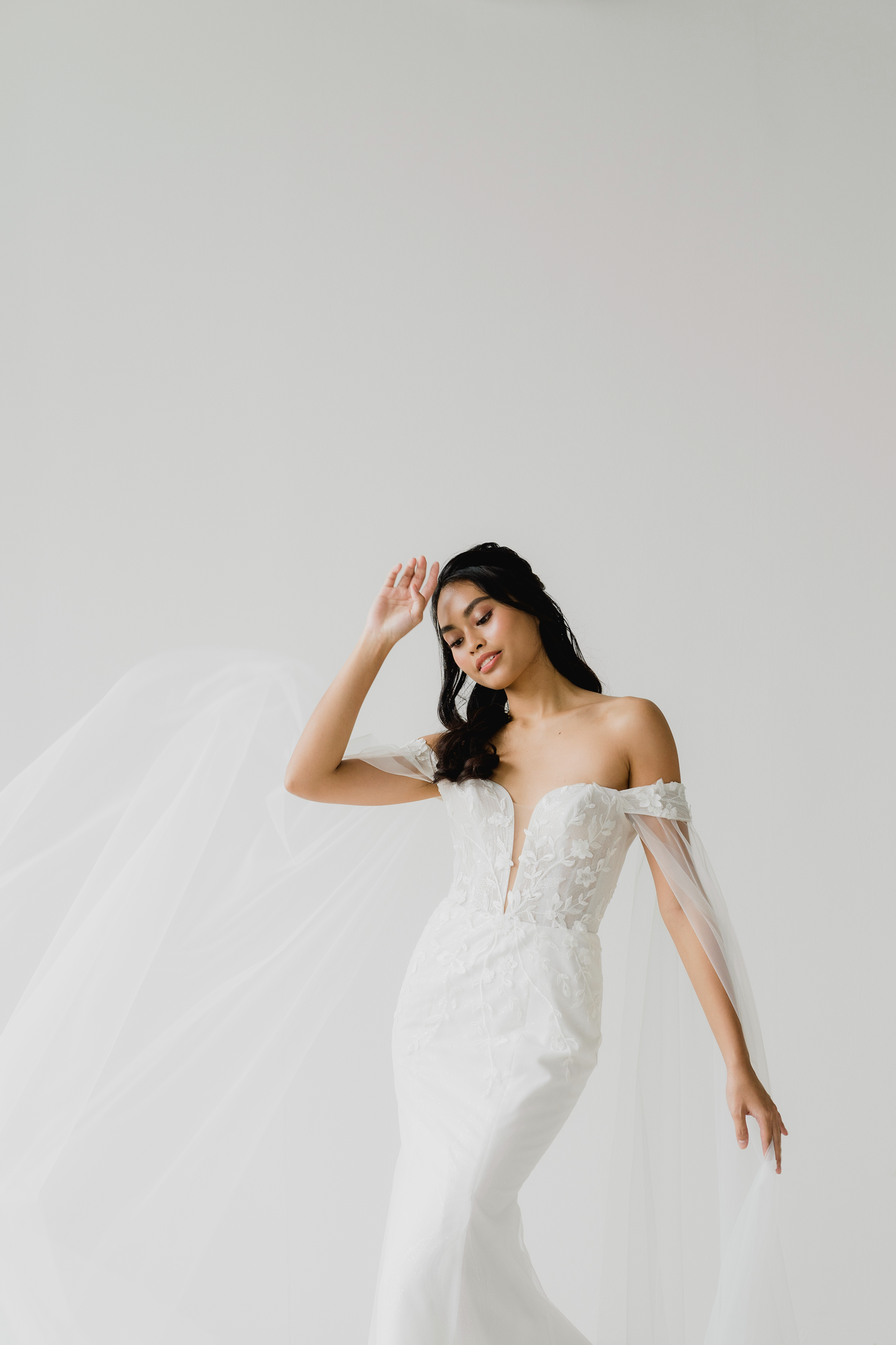 Elyse bridal gown featuring a sleek mermaid silhouette and detachable tulle cape