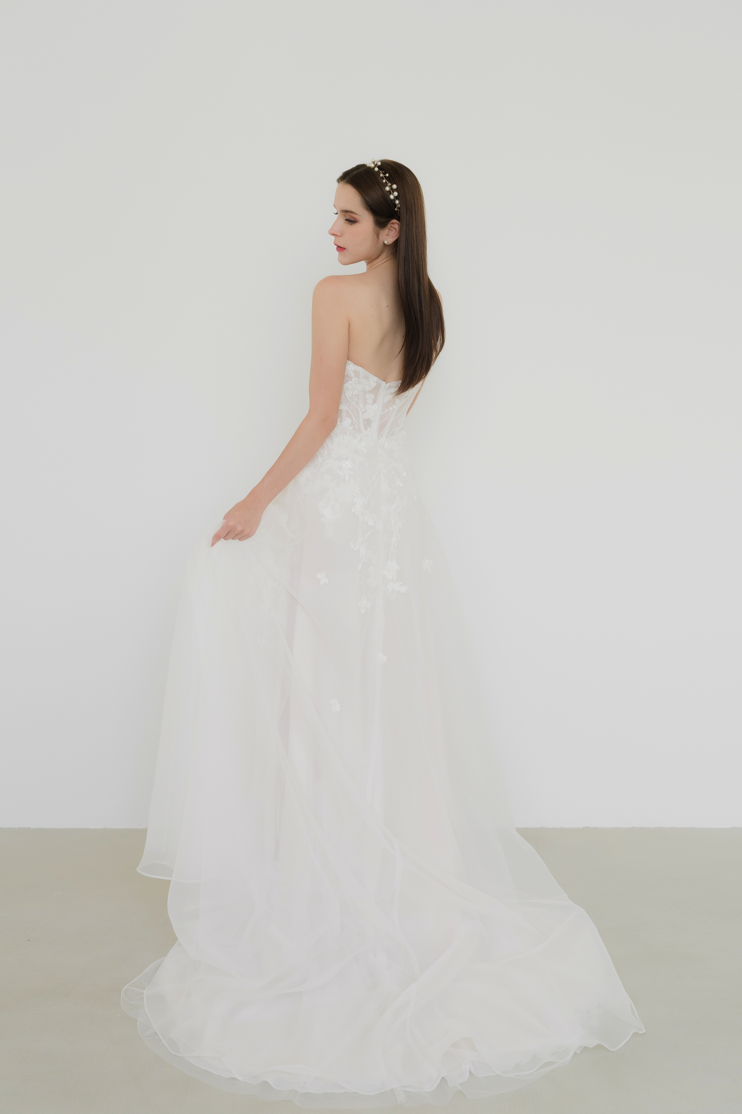 Close-up of Gladys wedding gown highlighting the flowing white organza layered over soft blush undertones