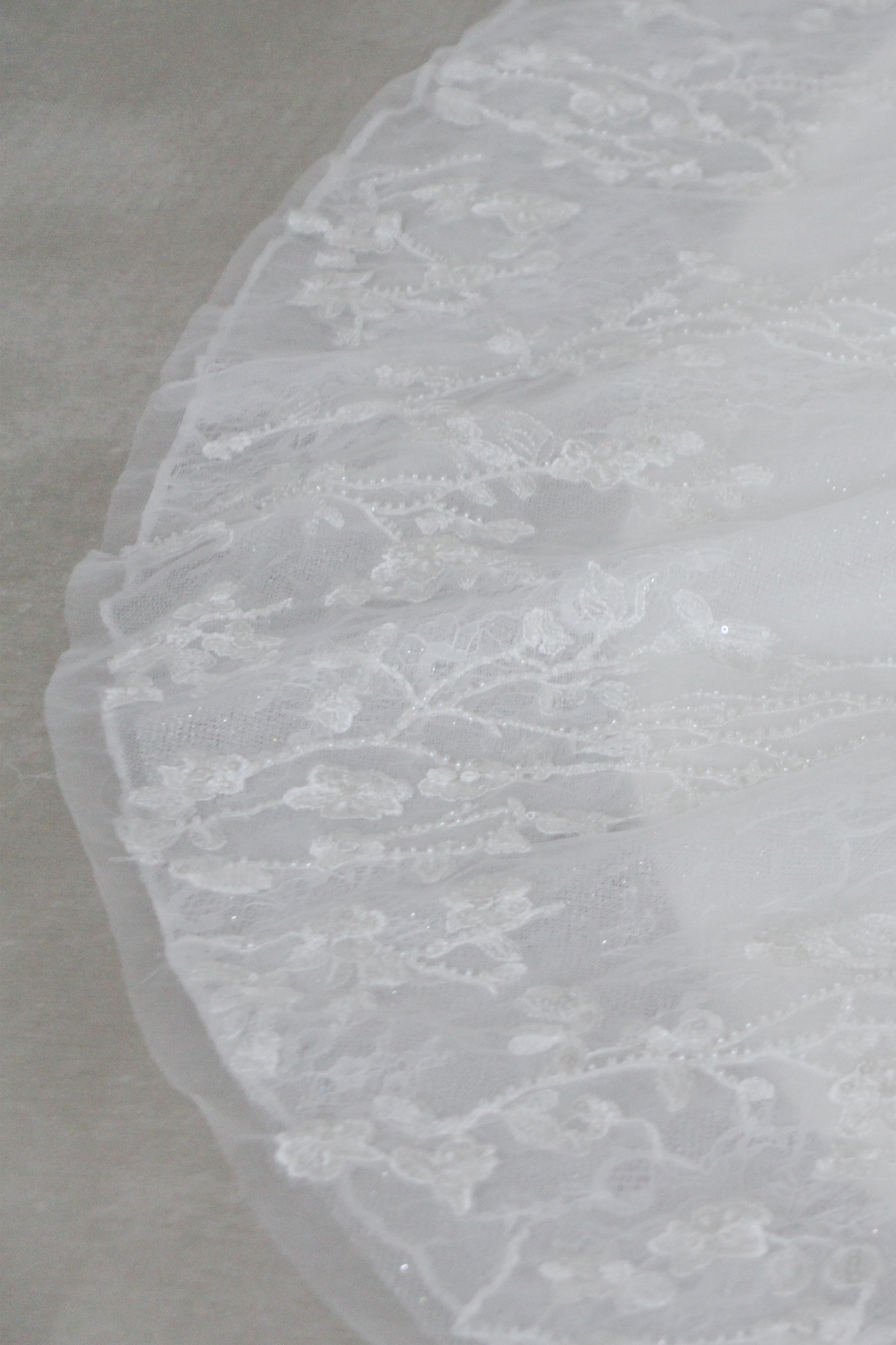Close-up of Isadora wedding dress highlighting the intricate floral lace and glitter tulle