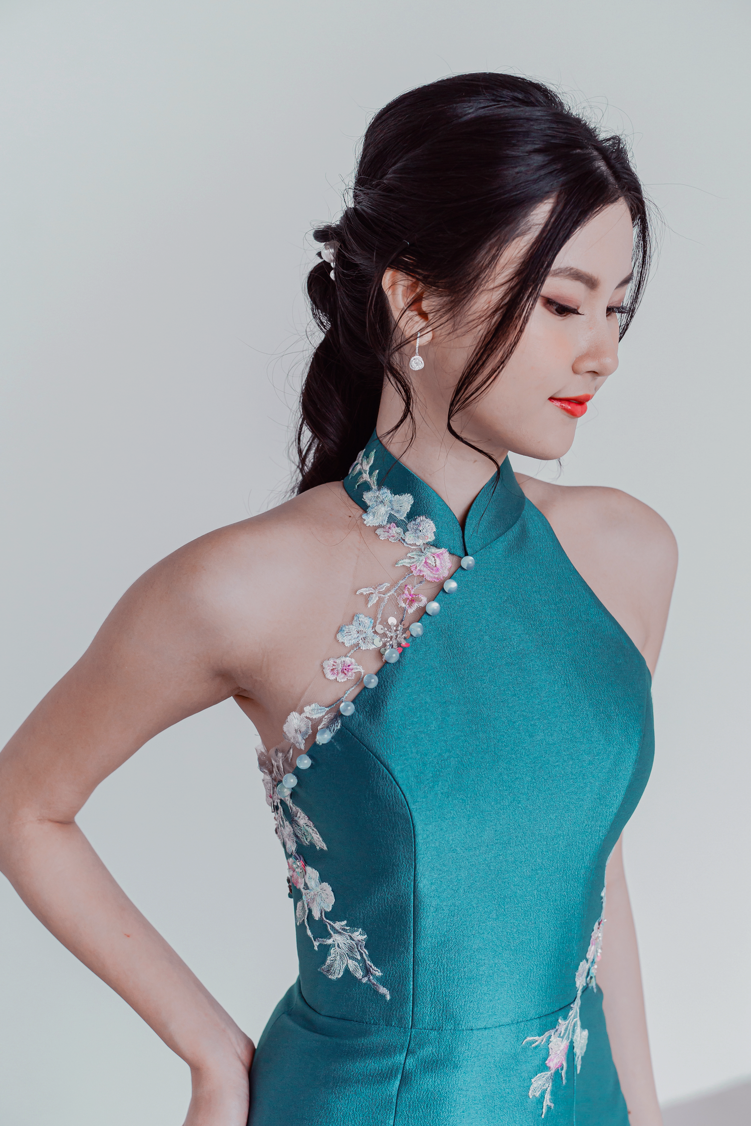 Close-up of Jade wedding cheongsam showcasing delicate floral lace accents