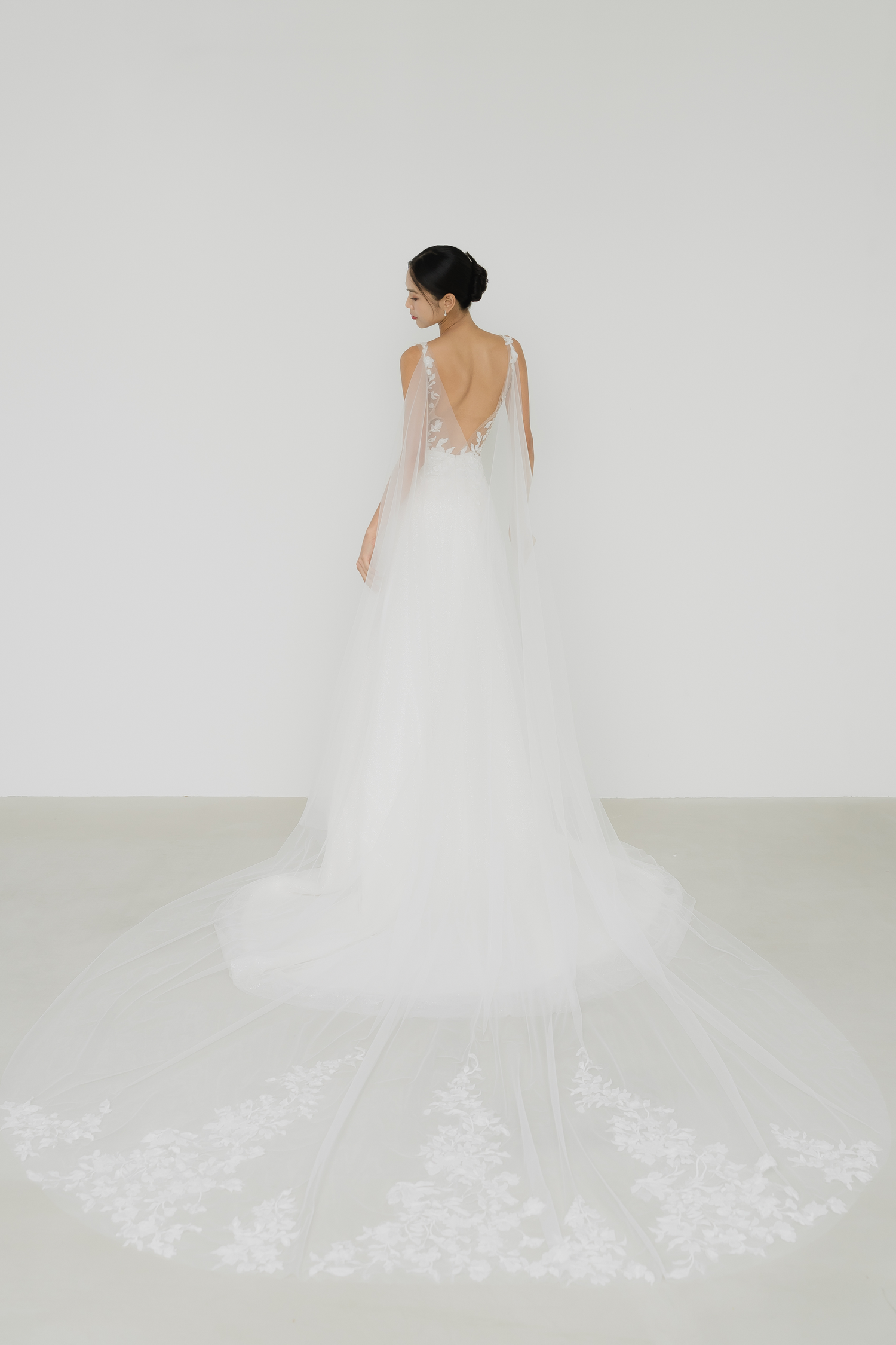 Jenica bridal gown with the detachable lace cape train creating a dramatic bridal look