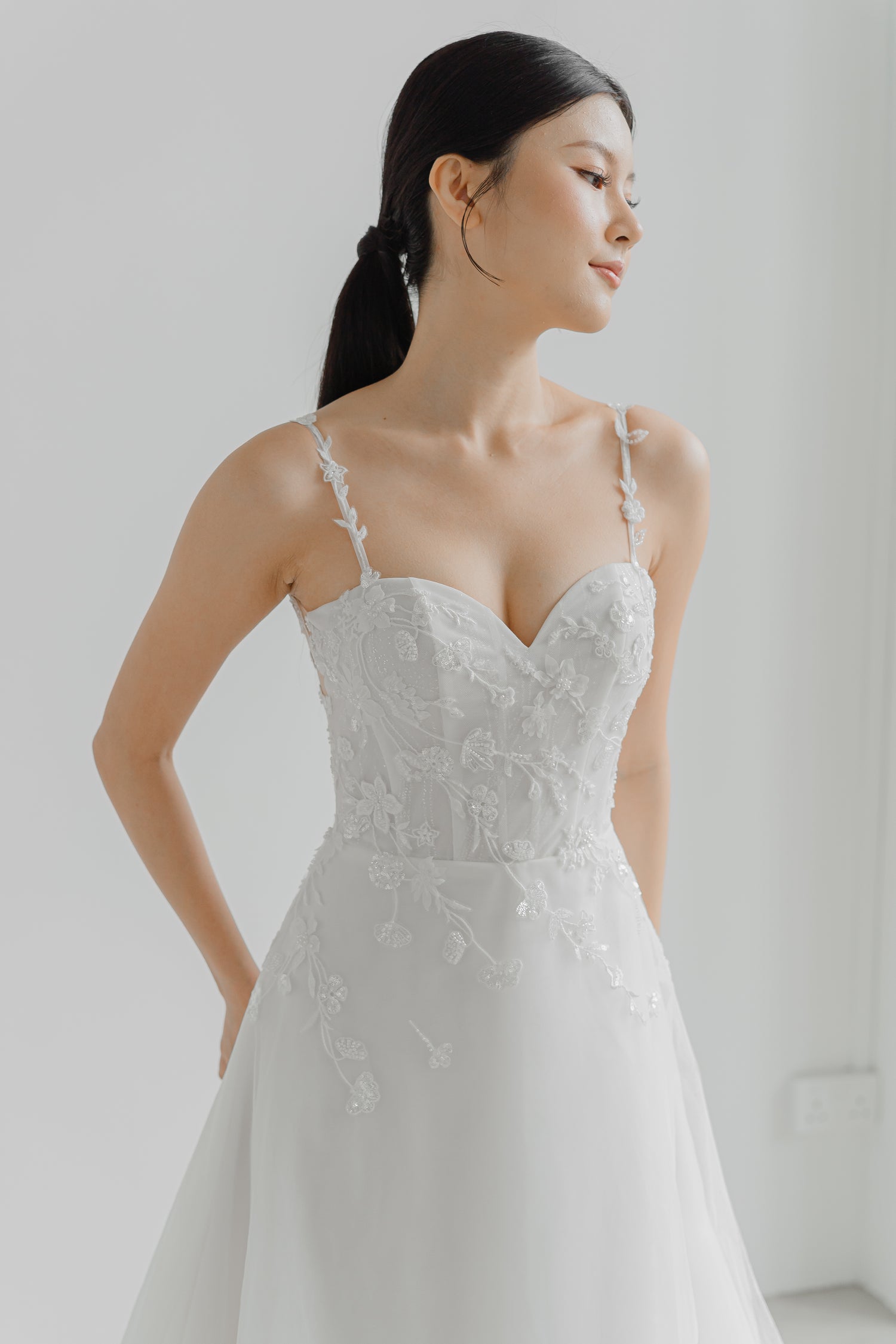Lyra wedding dress featuring intricate floral vine lace and shimmering glitter fabric