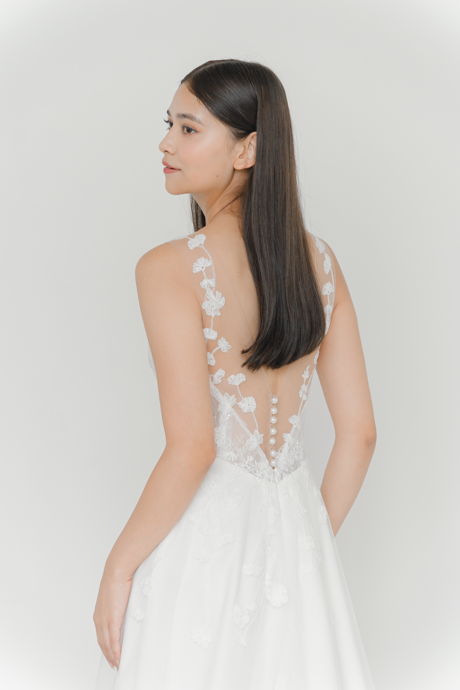 Close-up of Mikaela bridal gown showcasing the lace-trimmed back and pearl button detailing