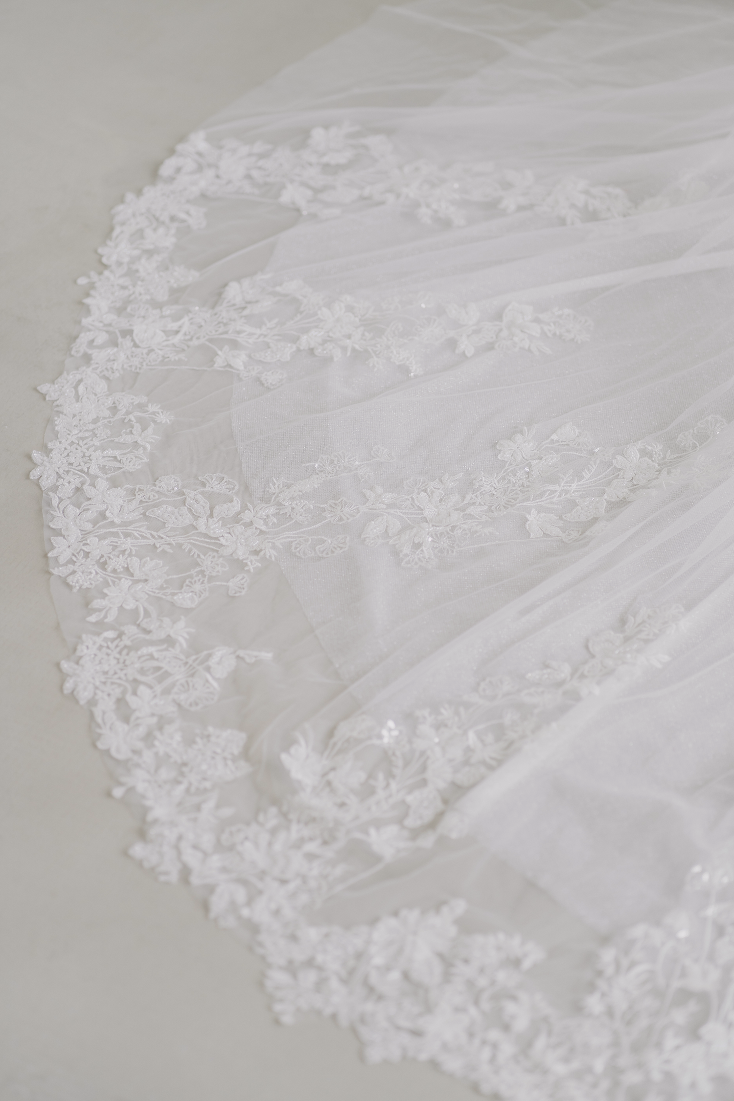 Close-up of Miriam wedding gown train with intricate beaded lace detailing