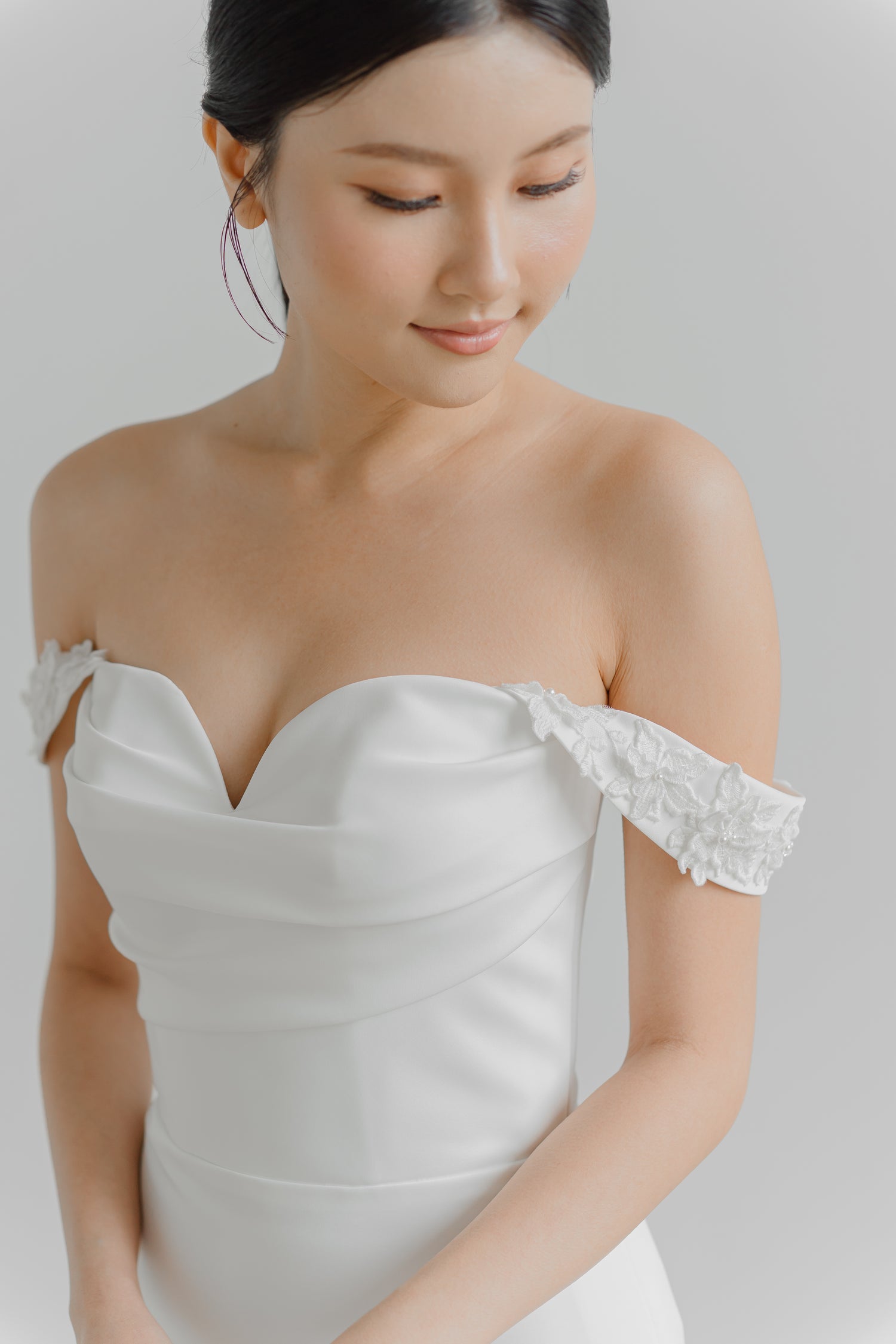 Close-up of Noelle bridal gown showcasing the detachable floral lace off-shoulder sleeves