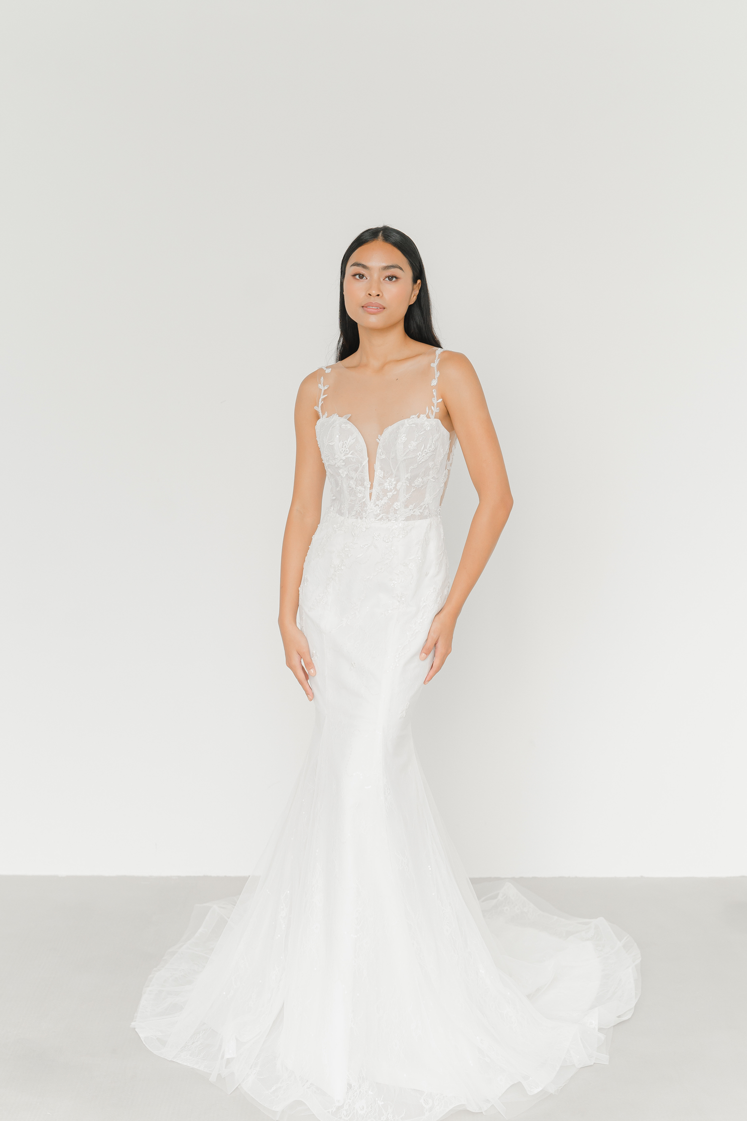 Rhea bridal gown front view with an illusion neckline and delicate floral lace