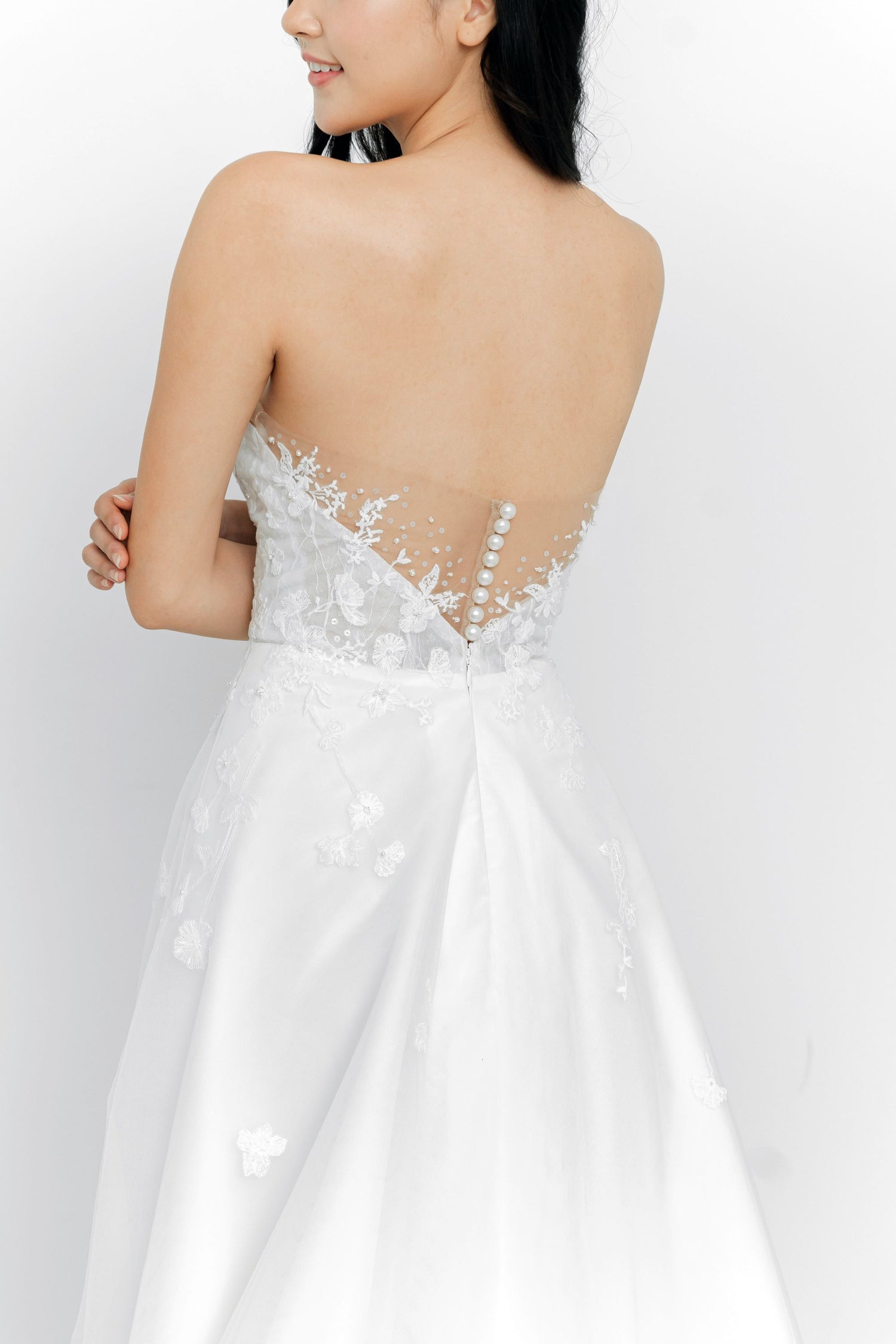 Close-up of Ruth bridal gown showcasing the illusion lace back with pearl buttons