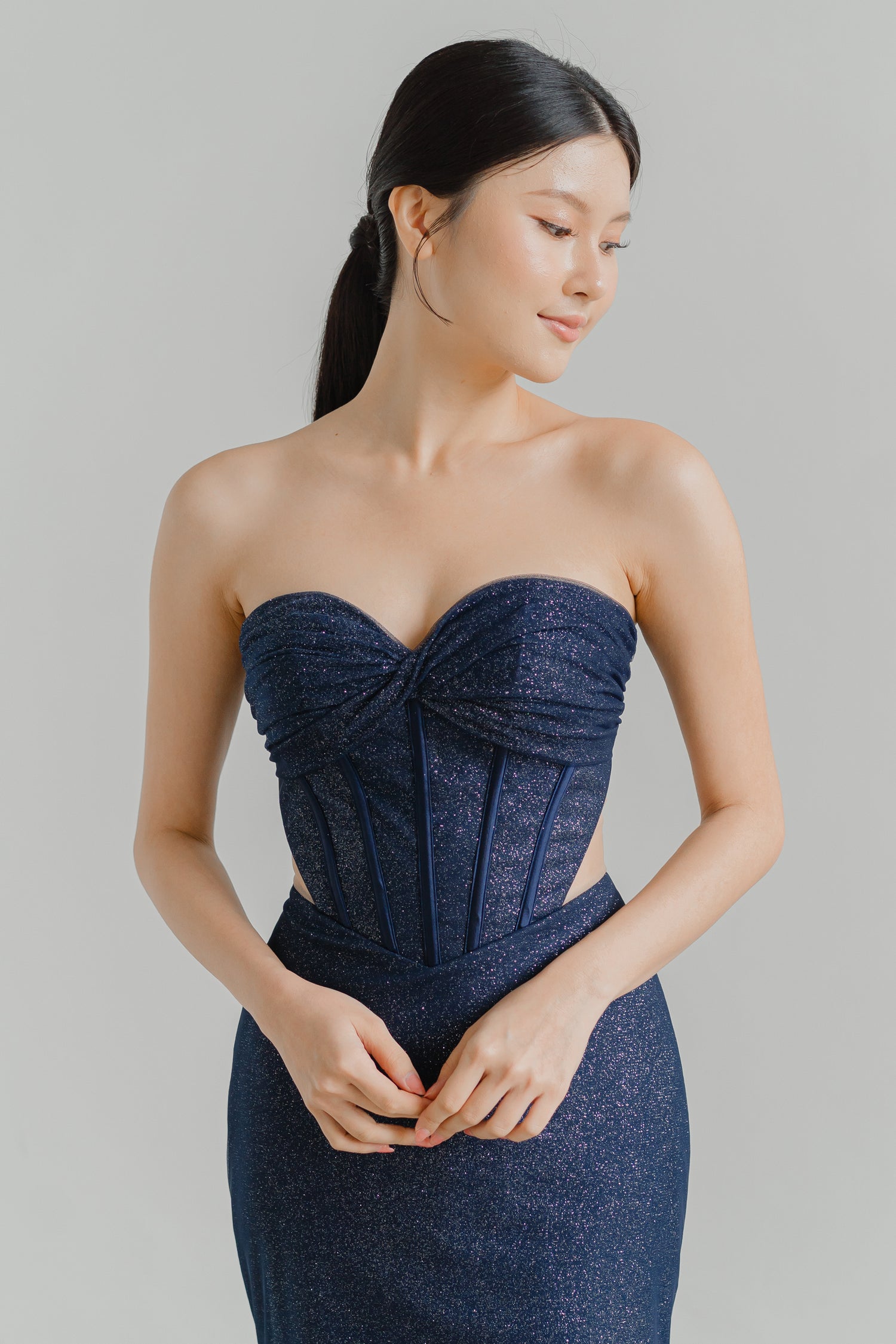 Solenne evening dress featuring a shimmering blue glitter base and structured corset bodice