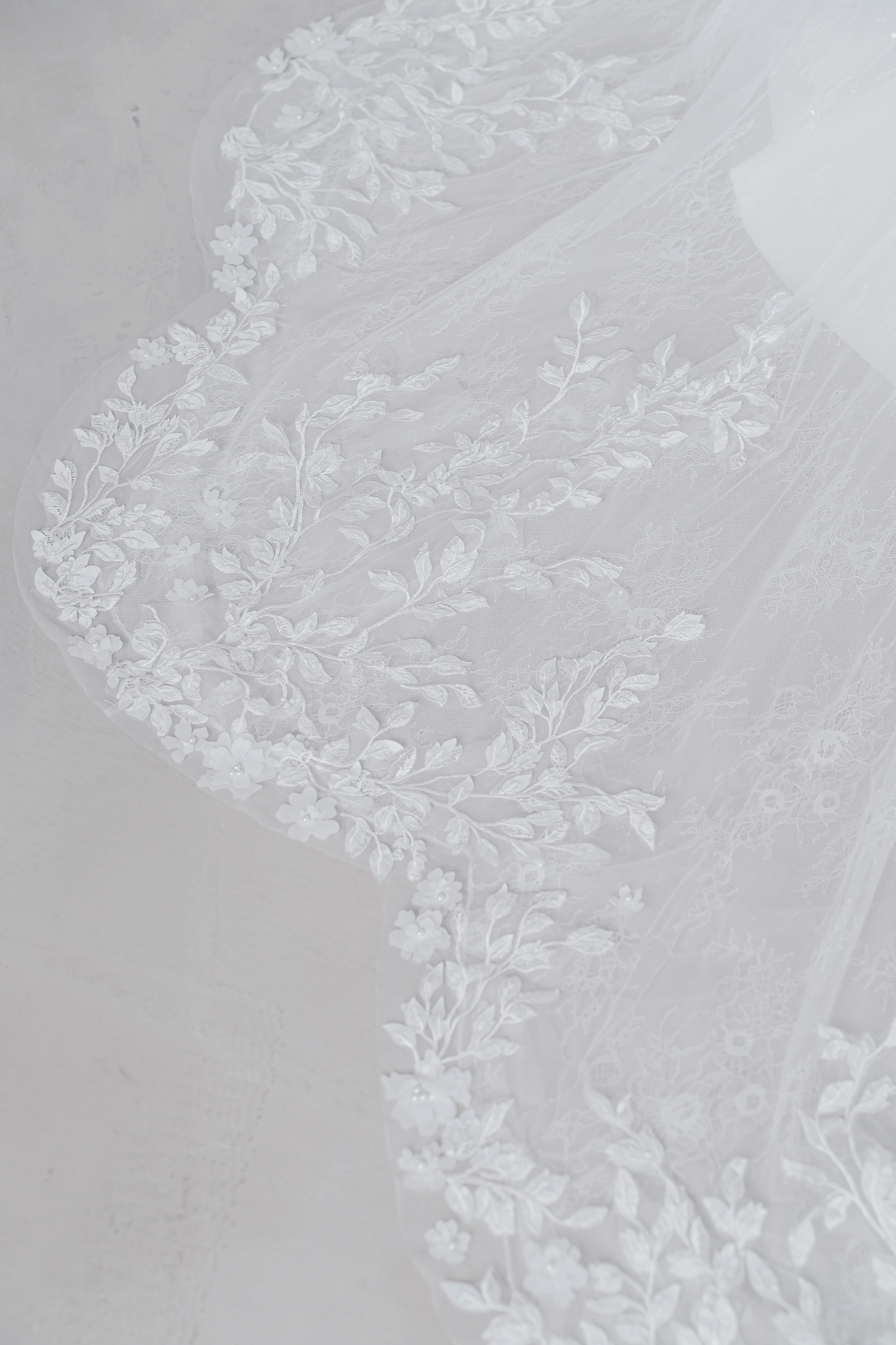 Close-up of Tricia bridal gown with intricate leafy lace appliqués